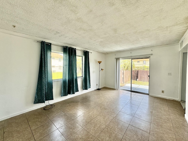 unfurnished room featuring light tile patterned flooring, ornamental molding, and a textured ceiling