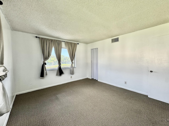 carpeted spare room featuring a textured ceiling