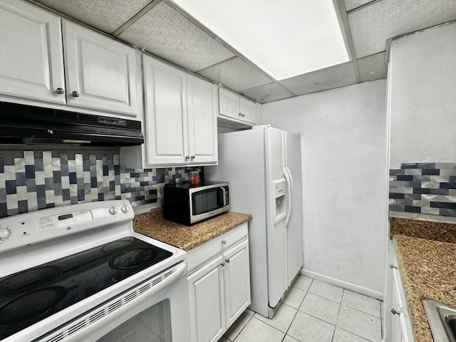 kitchen with light tile patterned flooring, white cabinetry, a paneled ceiling, white appliances, and decorative backsplash