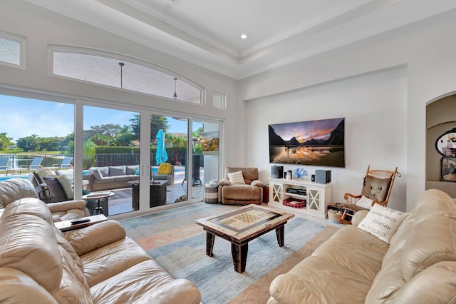 living room with crown molding, light hardwood / wood-style floors, and a high ceiling