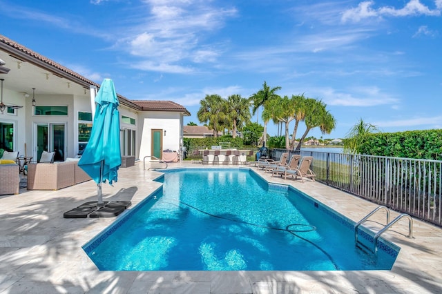 view of pool featuring a water view and a patio area