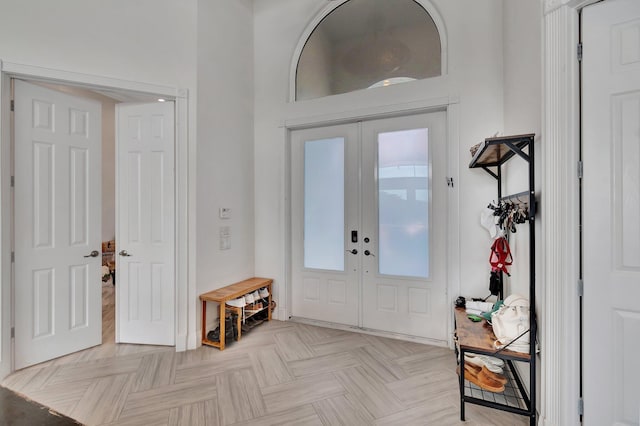 foyer entrance featuring light parquet floors and french doors