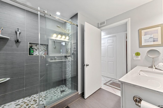 bathroom featuring vanity, tile patterned flooring, and a shower with door