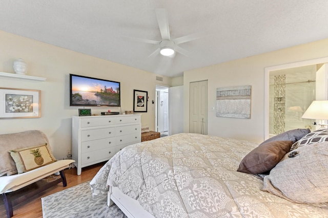 bedroom with ceiling fan, ensuite bath, wood-type flooring, and a closet