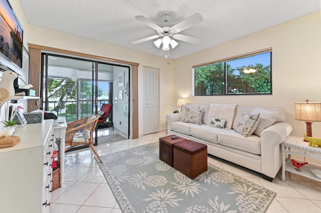 tiled living room featuring ceiling fan, plenty of natural light, and a textured ceiling