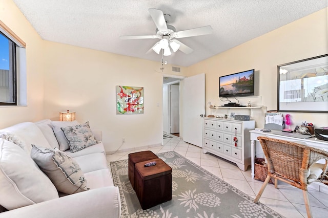 tiled living room featuring ceiling fan and a textured ceiling