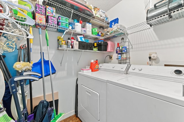 laundry room featuring washing machine and clothes dryer and a textured ceiling