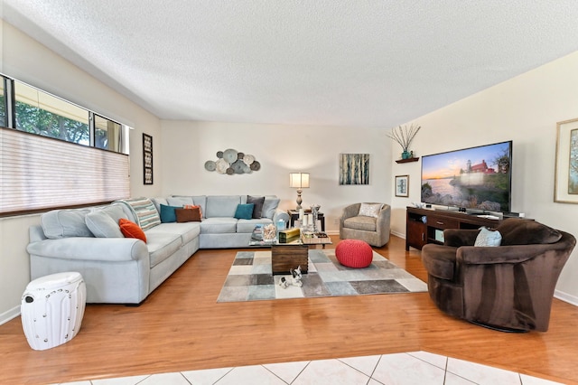 living room with a textured ceiling and light tile patterned flooring