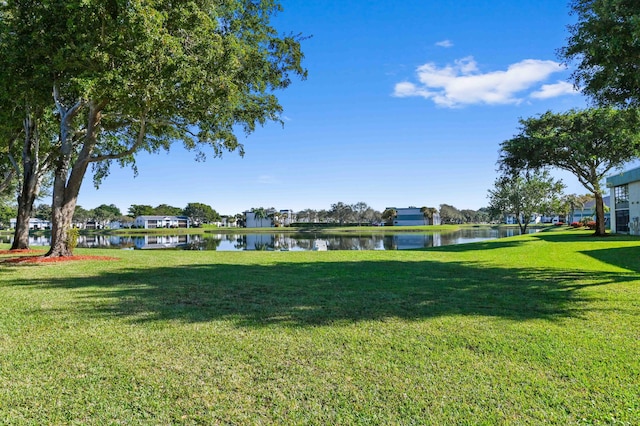 view of property's community with a yard and a water view