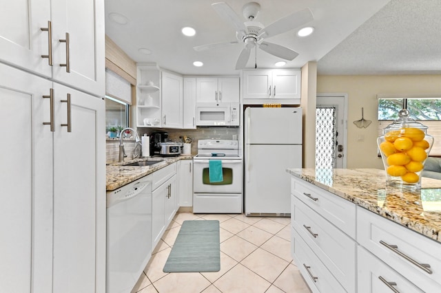 kitchen with light tile patterned flooring, white cabinetry, sink, backsplash, and white appliances