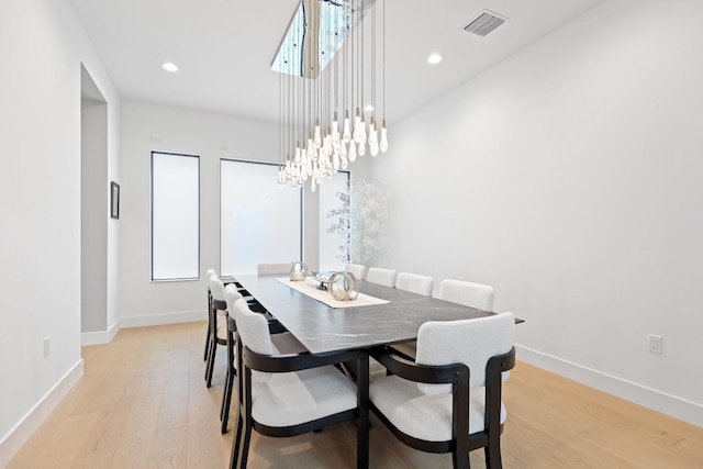 dining space with an inviting chandelier and light hardwood / wood-style floors