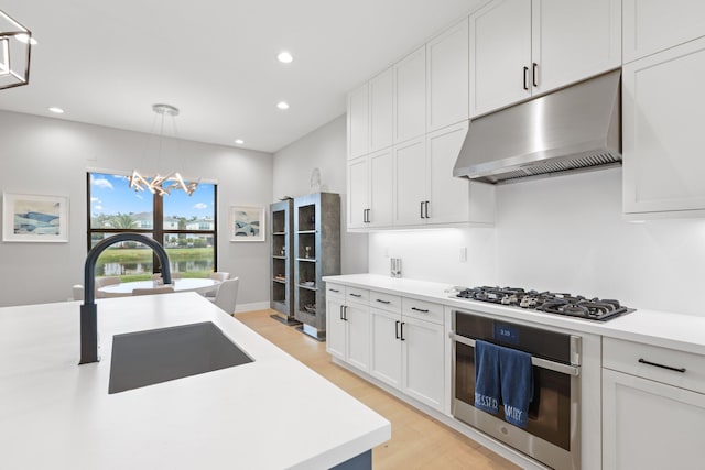 kitchen featuring white cabinetry, appliances with stainless steel finishes, sink, and pendant lighting