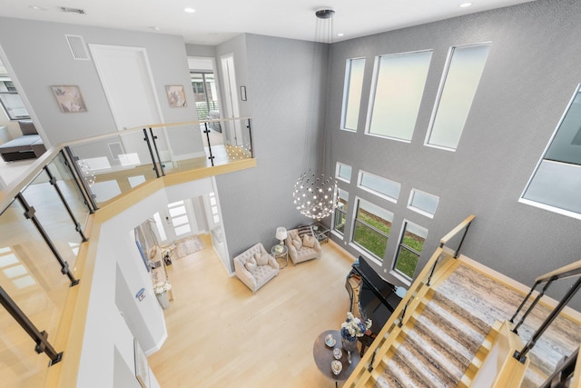 living room featuring a towering ceiling and wood-type flooring