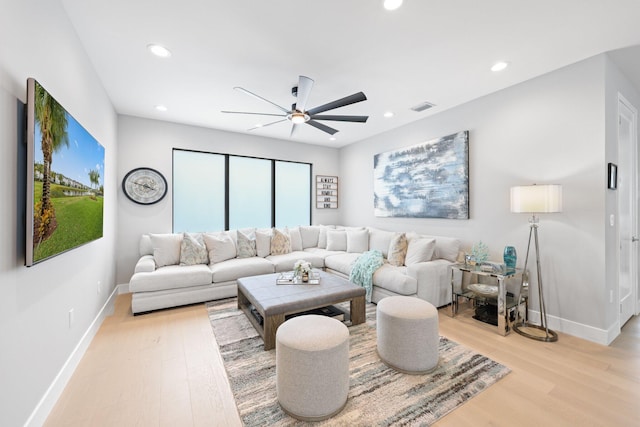 living room featuring light hardwood / wood-style flooring and ceiling fan