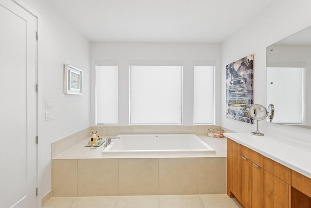 bathroom featuring vanity, tile patterned flooring, and tiled tub