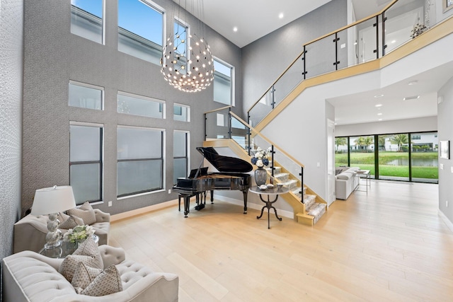 interior space featuring a high ceiling, a chandelier, and light wood-type flooring