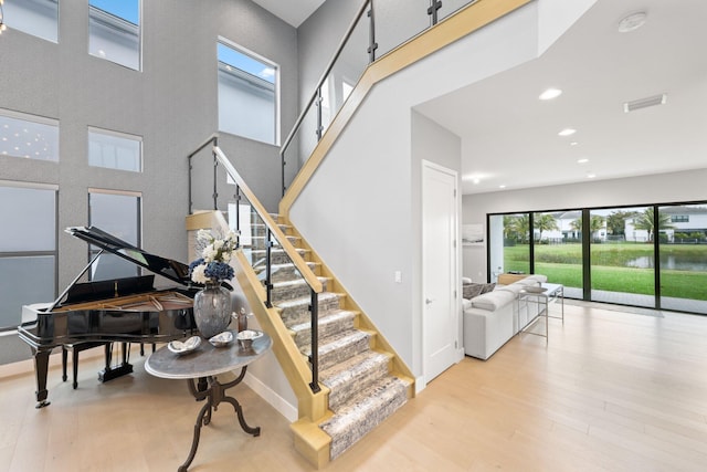 staircase featuring a high ceiling and hardwood / wood-style floors