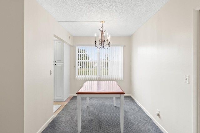 unfurnished dining area with light colored carpet, a chandelier, and a textured ceiling