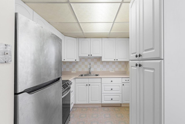 kitchen featuring a paneled ceiling, tasteful backsplash, sink, white cabinets, and stainless steel appliances