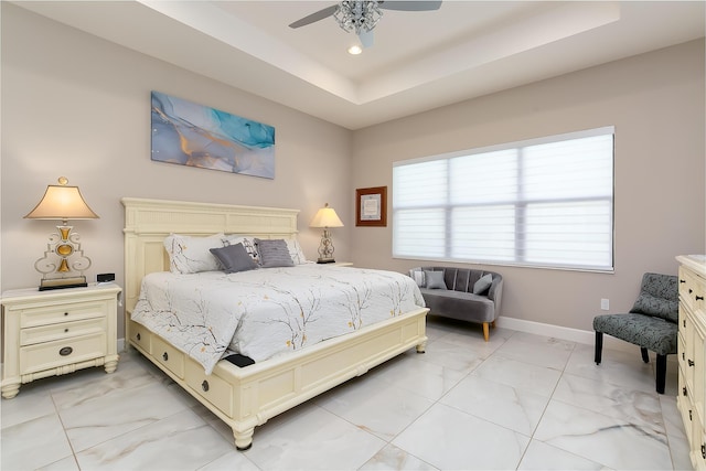 bedroom with a raised ceiling and ceiling fan