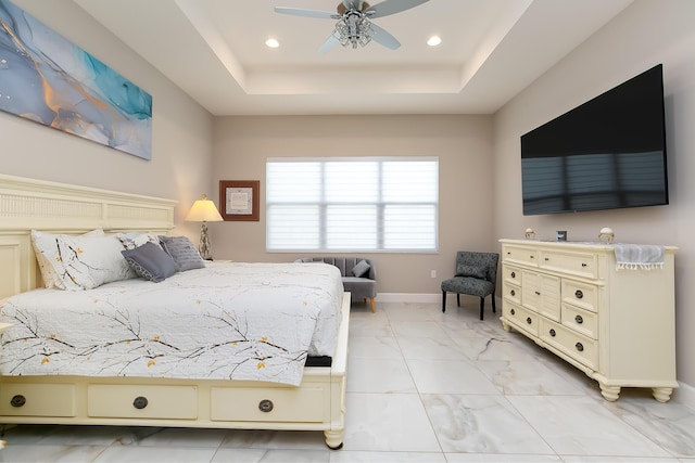 bedroom featuring a raised ceiling and ceiling fan