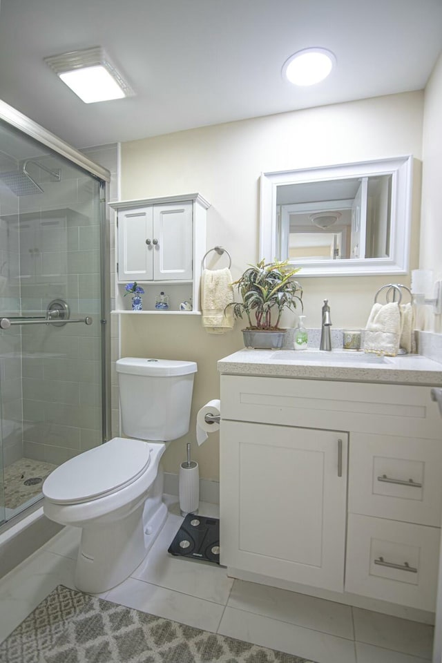 bathroom with toilet, vanity, tile patterned floors, and walk in shower