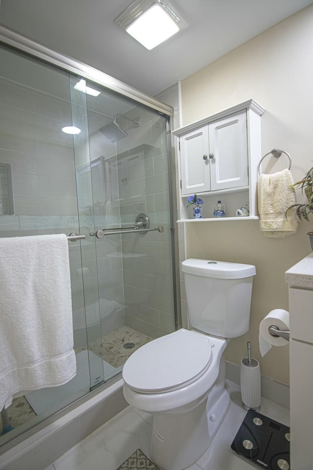 bathroom with vanity, a shower with shower door, and toilet