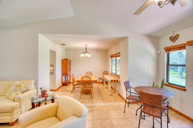 dining area featuring visible vents, lofted ceiling, ceiling fan with notable chandelier, light tile patterned flooring, and a textured ceiling