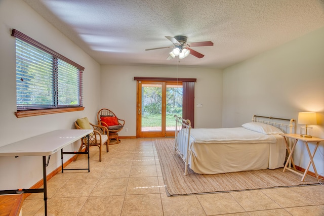 bedroom featuring light tile patterned floors, baseboards, ceiling fan, access to exterior, and a textured ceiling