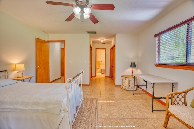 bedroom with light tile patterned floors, a ceiling fan, baseboards, visible vents, and a textured ceiling