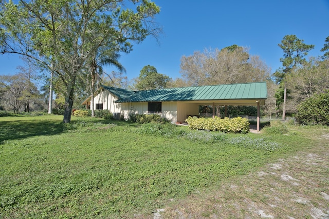 exterior space with a lawn, metal roof, and a standing seam roof