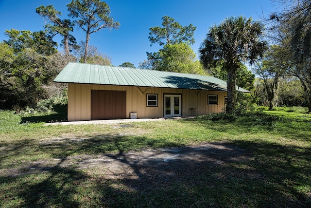 exterior space with french doors, metal roof, and driveway