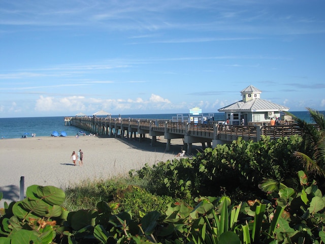 property view of water with a pier and a view of the beach