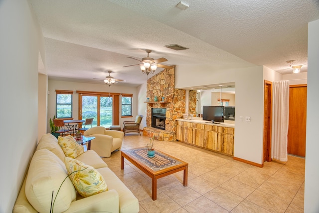 living room with visible vents, lofted ceiling, a textured ceiling, and a fireplace