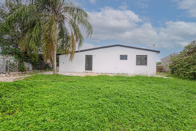 back of house featuring a lawn