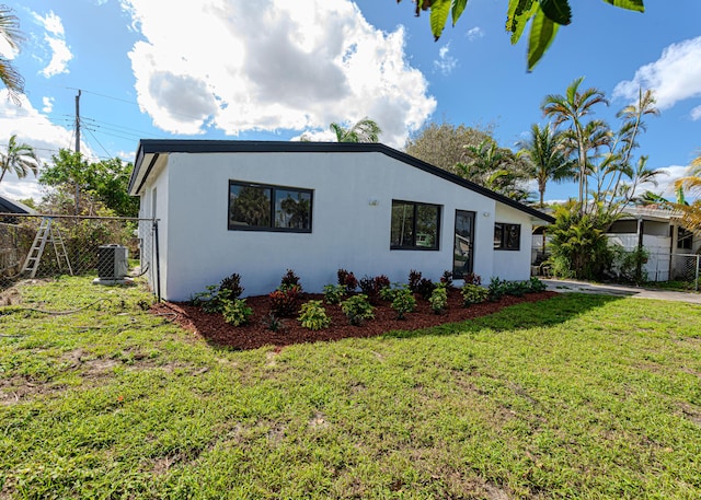 view of front of house featuring cooling unit and a front lawn