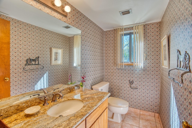 bathroom featuring vanity, visible vents, wallpapered walls, tile patterned flooring, and toilet