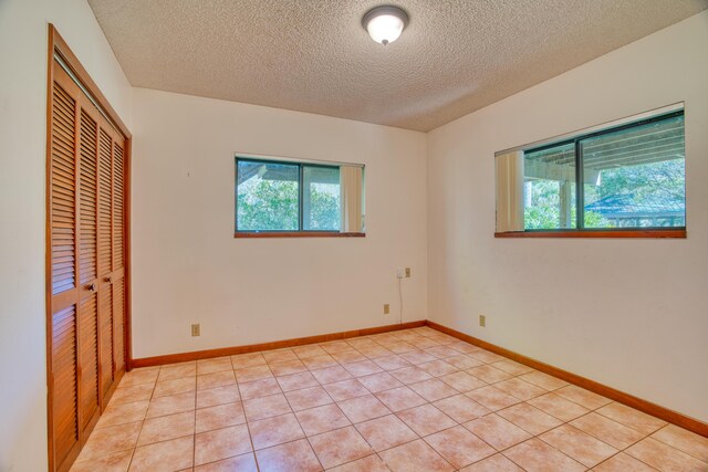 unfurnished bedroom with a closet, multiple windows, and baseboards