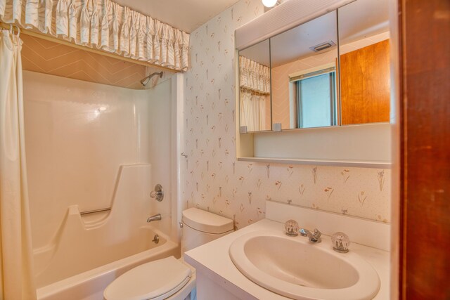 full bathroom featuring shower / bathing tub combination, toilet, vanity, and wallpapered walls