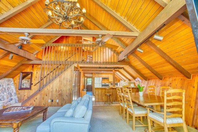 interior space with wooden walls, track lighting, vaulted ceiling with beams, carpet, and wood ceiling