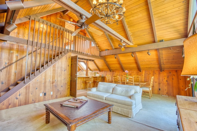 carpeted living room with vaulted ceiling with beams, rail lighting, wood ceiling, wood walls, and ceiling fan with notable chandelier