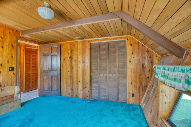 unfurnished bedroom featuring beam ceiling, wood ceiling, and wood walls