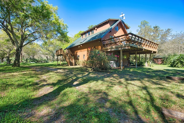 rear view of property with stairway, a wooden deck, and a yard