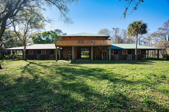 back of property featuring central AC unit, a wooden deck, a lawn, and metal roof