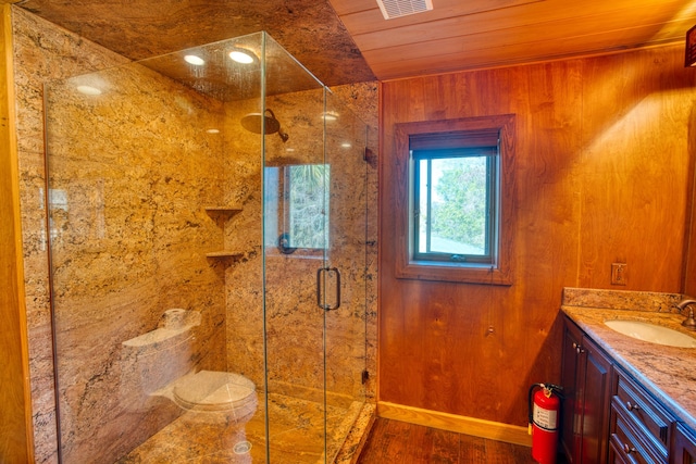 bathroom featuring vanity, wood finished floors, baseboards, a shower stall, and wooden ceiling