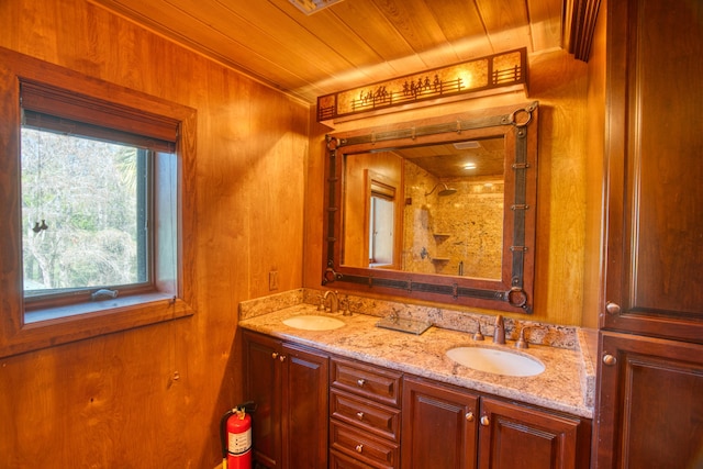 full bath with double vanity, walk in shower, wood ceiling, and a sink