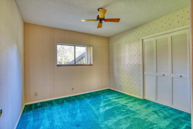 unfurnished bedroom with a ceiling fan, baseboards, a closet, a textured ceiling, and carpet flooring