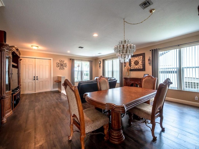 dining room with ornamental molding, an inviting chandelier, and dark hardwood / wood-style flooring