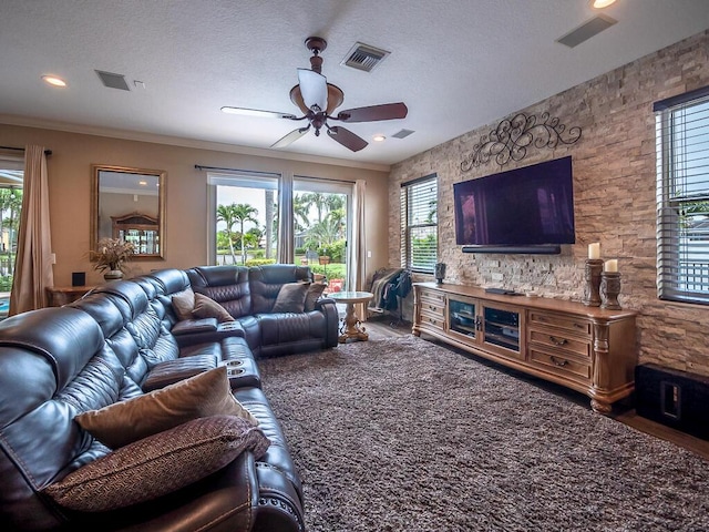 living room with crown molding, ceiling fan, and a textured ceiling