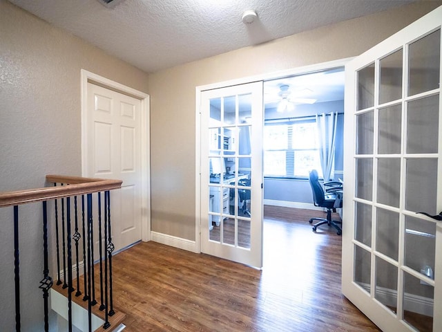 entryway featuring wood-type flooring, french doors, and a textured ceiling